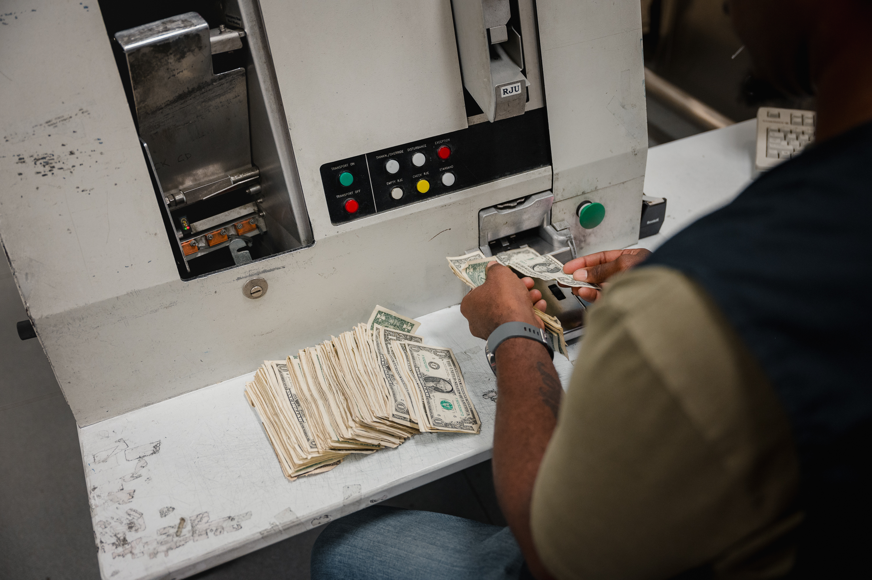 BALTIMORE, MD - JULY 12, 2023:  An employee works at the reconciliation station to manually process currency at the Federal Reserve Bank of Richmond in Baltimore, MD. on Wednesday, July 12, 2023. Fit currency is any currency the currency processor deems as adequate to put back into the public. (Photo by Hannah Yoon for The Washington Post)